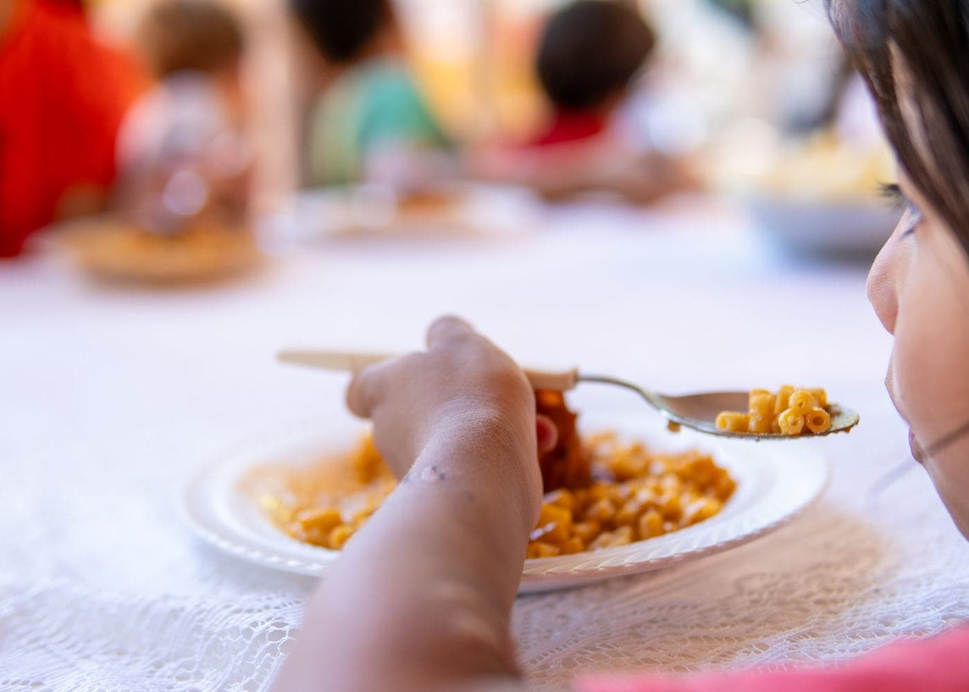 Una niña almuerza en un comedor comunitario abastecido por el Banco de Alimentos
